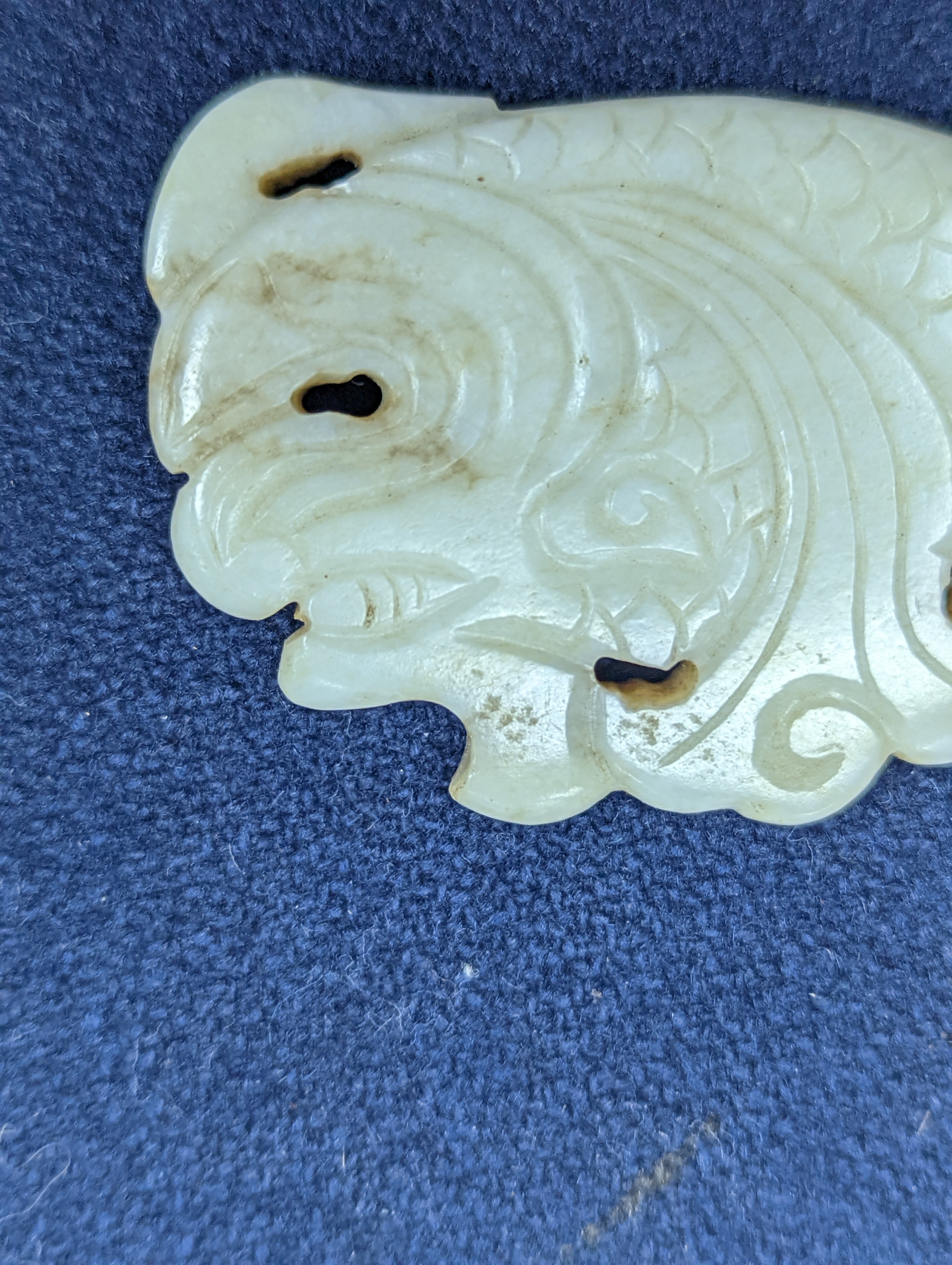 A Chinese white and black jade ‘dragon-fish’ plaque, 19th/20th century, 6cm